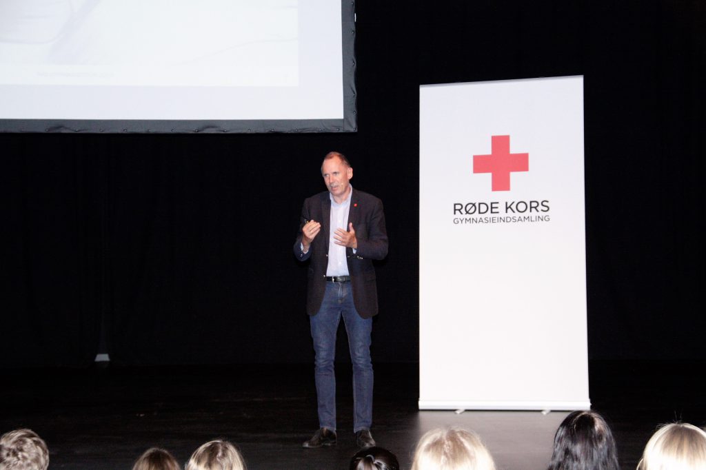 Anders Ladekarl foran roll-up med Røde Kors logo på scenen i Vesthimmerlands Musikhus ALFA.