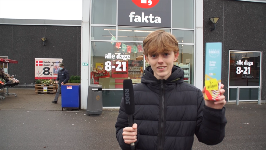 En af film-drengene står foran Fakta og fortæller om mulighed for at købet "Stop madspild" produkter.
