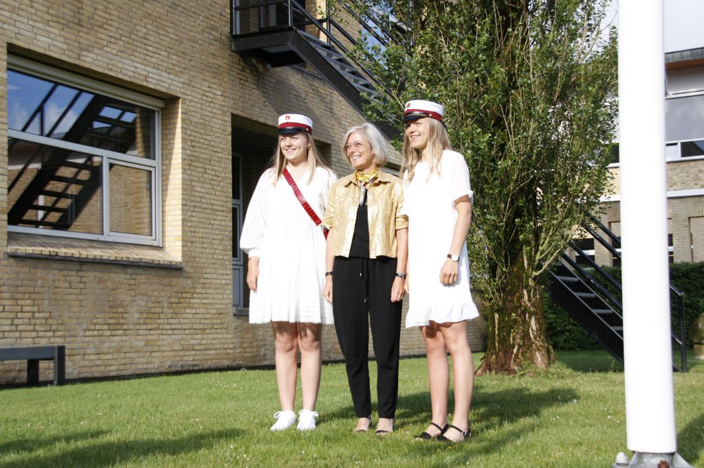 Rektor Jette Rygaard foran gymnasiet med de to første studenter i 2020; Caroline og Mathilde Liltorp Justesen