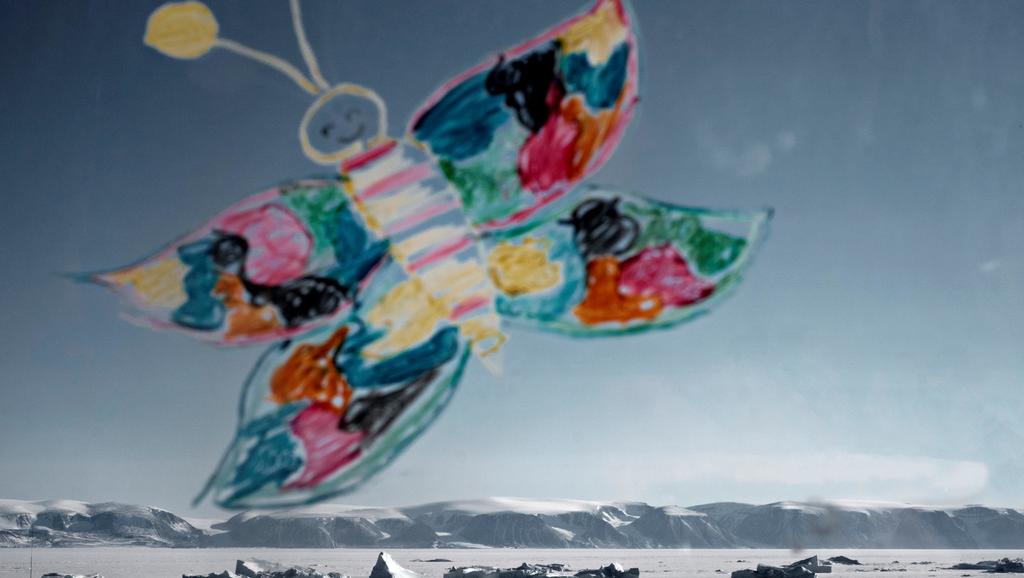 Sommerfugl malet på rude. Grønlands indlandsis ses i baggrunden.
