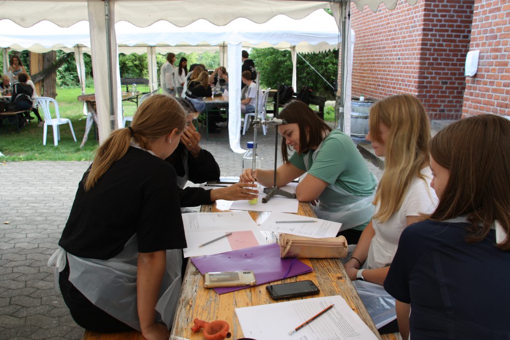 Fem elever sidder ved et bord og laver gruppearbejde på Livø.