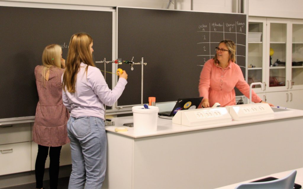 Sara i en undervisningssituation sammen med to elever oppe ved tavlen.