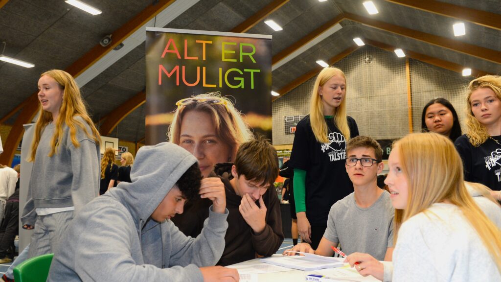 Elever sidder og arbejder med matematik-workshop i hallen i Brønderslev.