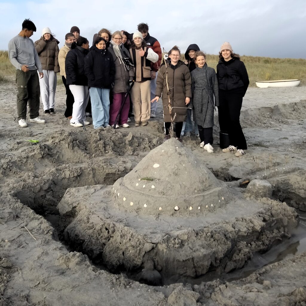 Ryste-sammen-aktivitet for 1g-elever, der bygger sandslotte på stranden i Sæby.