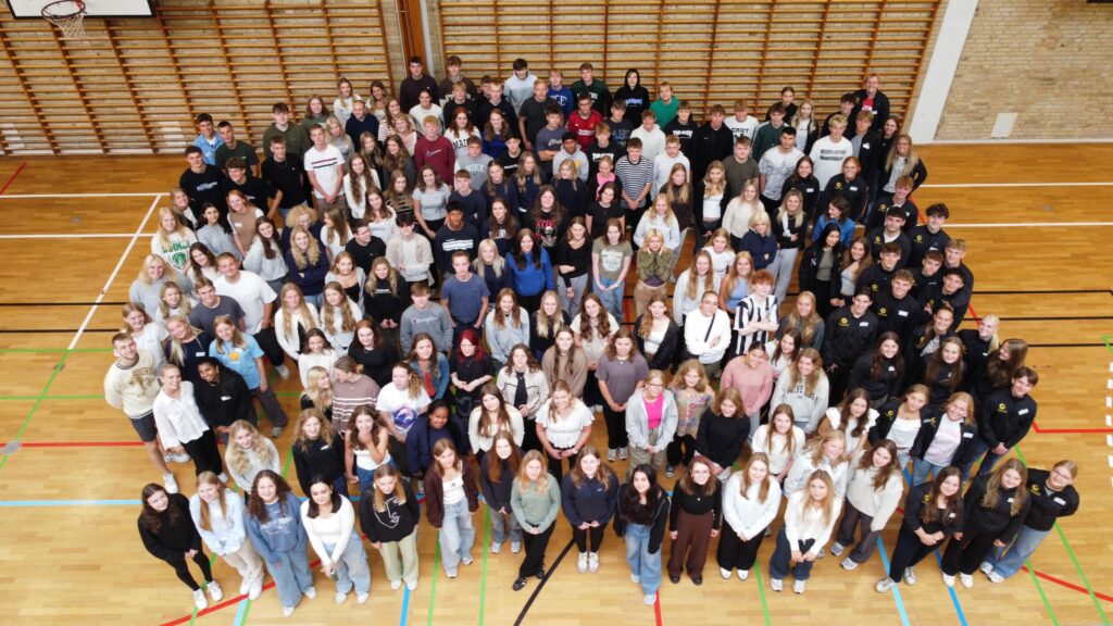 Gruppebillede fra første skoledag 2023 - alle elever i hallen fotograferet oppefra med drone.